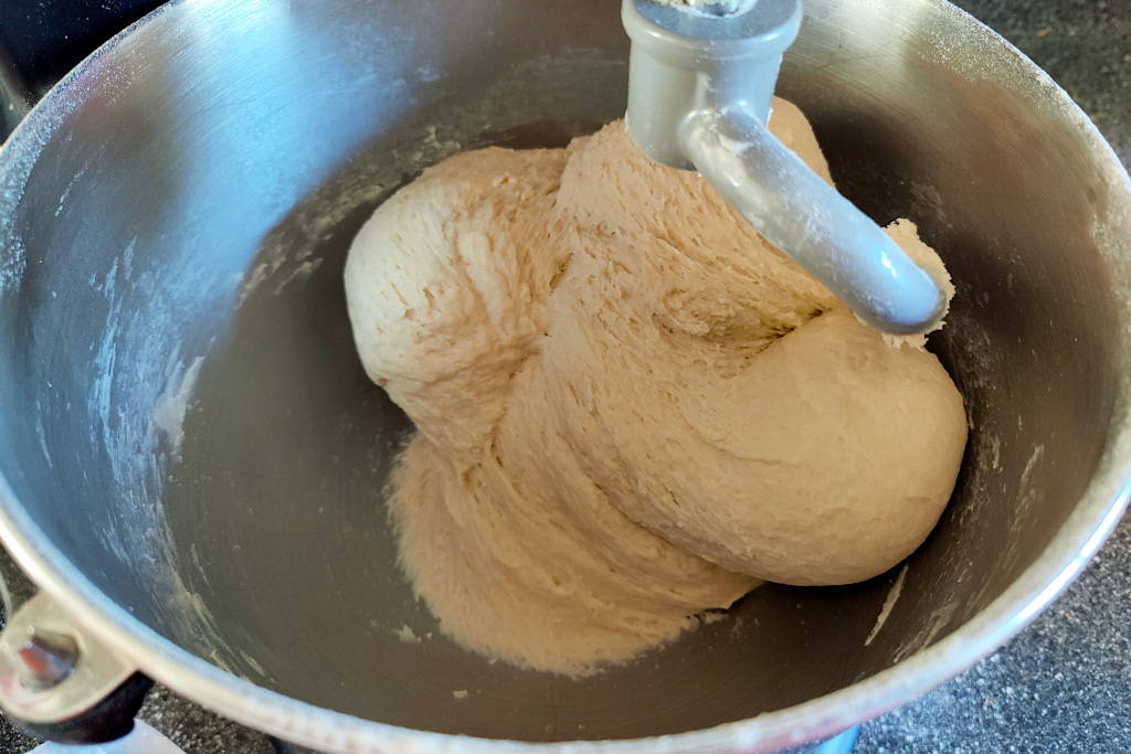 Sandwich bread dough finished being kneaded in a stand mixer.